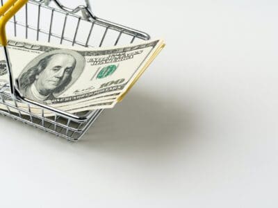 Toy shopping cart with American Dollars inside. Purchasing power and living wage concept